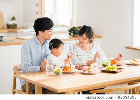 A young family eating 98054203