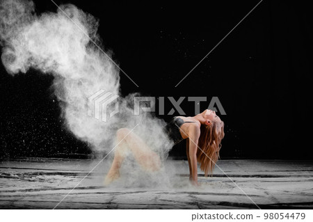 Young slim woman with spread flour on the air Young slim woman with spread flour on the air 98054479