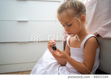 Little girl make ceramic decor sitting floor 98055394