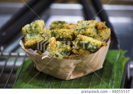 steamed chives dumplings in a container from dried banana leaves 98055537