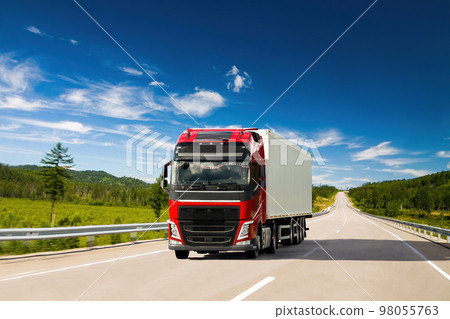 Red truck on a road in summer 98055763