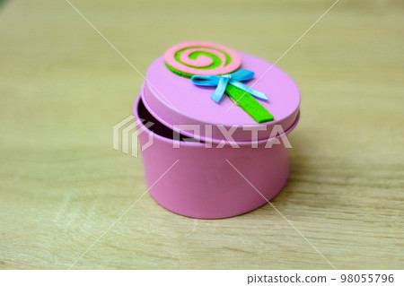 A small pink box with a lid for storing small things is on the table in the apartment A small pink box with a lid for storing small things is on the table in the apartment 98055796