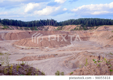 A deep sand pit with yellow and white sand with green trees along the edge A deep sand pit with yellow and white sand with green trees along the edge 98055818