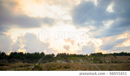 sunset with storm clouds over a quarry and forest in summer 98055831