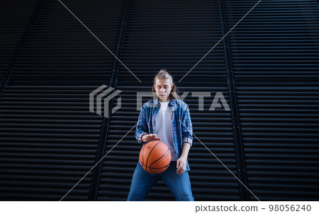 Young man dribbling with basketball ball,outdoor in city. Youth culture. Young man dribbling with basketball ball,outdoor in city. Youth culture. 98056240