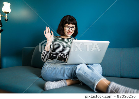 Attractive woman using laptop for communication, video chatting. Online meeting in video call. 98056256