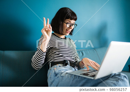 Attractive woman using laptop for communication, video chatting. Online meeting in video call. 98056257