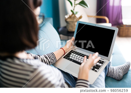 Beautiful woman working on laptop at home. Black screen on laptop. Technology, freelance. Beautiful woman working on laptop at home. Black screen on laptop. Technology, freelance. 98056259