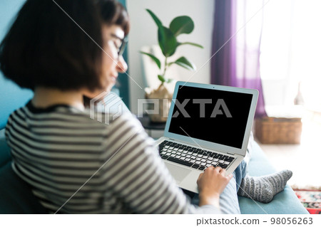 Beautiful woman working on laptop at home. Black screen on laptop. Technology, freelance. Beautiful woman working on laptop at home. Black screen on laptop. Technology, freelance. 98056263