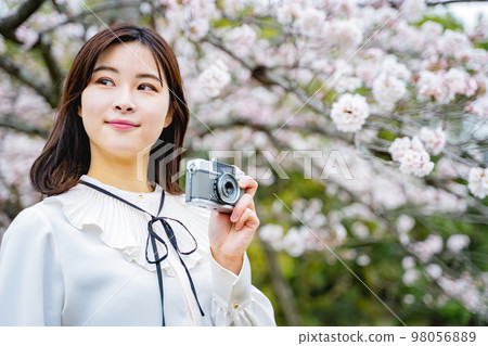 一個拿著相機看櫻花的女人 一個拿著相機看櫻花的女人 98056889
