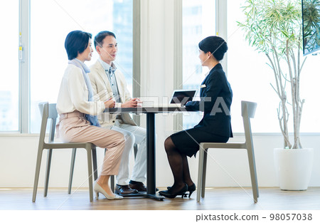 A business woman who sells to a middle-aged couple A business woman who sells to a middle-aged couple 98057038