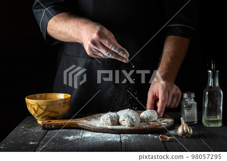 The chef prepares cutlets before frying in the restaurant kitchen. The idea of making a delicious lunch or dinner 98057295