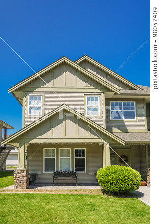 Suburban residential house with green lawn in front 98057409