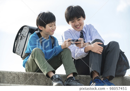 brothers playing games on smartphones 98057451
