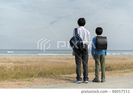 Elementary school and junior high school brothers looking at the sea 98057551