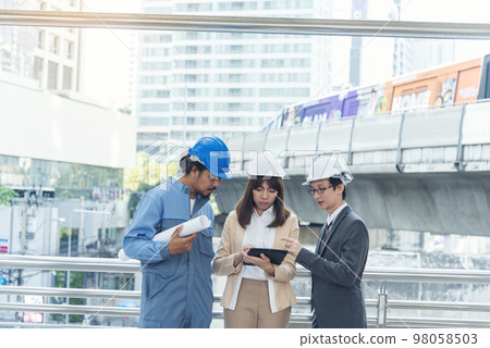Civil engineer teams meeting working together wear worker helmets hardhat on construction site in modern city. Foreman industry project manager engineer teamwork. Asian industry professional team Civil engineer teams meeting working together wear worker helmets hardhat on construction site in modern city. Foreman industry project manager engineer teamwork. Asian industry professional team 98058503