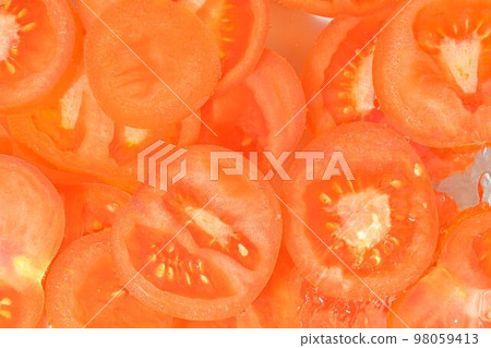 Close-up fresh slices of tomato on white background. Slices of tomato in sparkling water on white background, close-up. Horizontal image 98059413