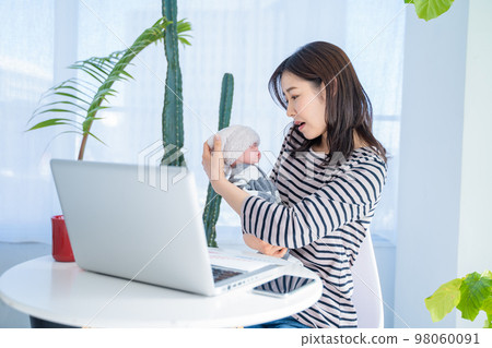 Woman video chatting while watching her child working from home Woman video chatting while watching her child working from home 98060091