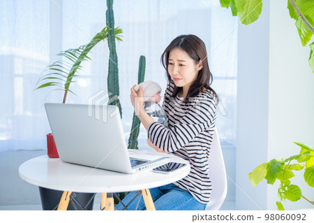 Woman video chatting while watching her child working from home 98060092