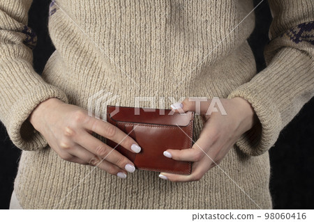 Leather wallet in female hands close-up. Leather wallet in female hands close-up. 98060416