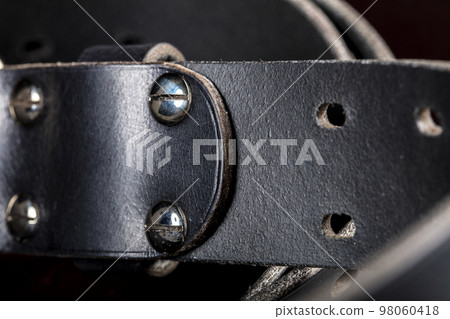 Black leather belt on a dark background. Leather products. 98060418