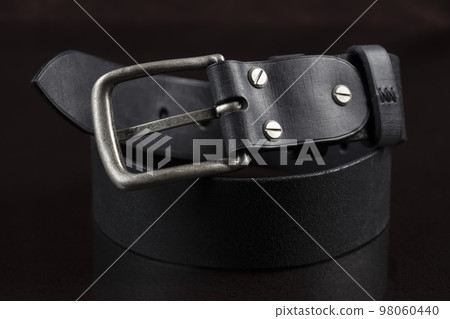 Black leather belt on a dark background. Leather products. 98060440