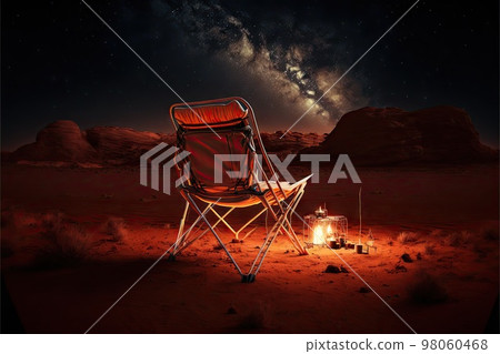 Back view of camp chair near campfire on Mars with star trail in night sky 98060468