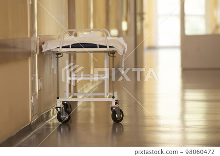 Hospital corridor with a medical gurney in beige tones. Hospital corridor with a medical gurney in beige tones. 98060472
