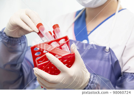 The doctor laboratory assistant holds test tubes with analyzes in his hands. The doctor laboratory assistant holds test tubes with analyzes in his hands. 98060724