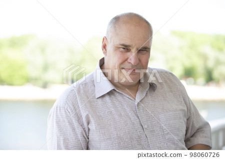 Portrait of an elderly man of European appearance. He looks into the camera. Portrait of an elderly man of European appearance. He looks into the camera. 98060726