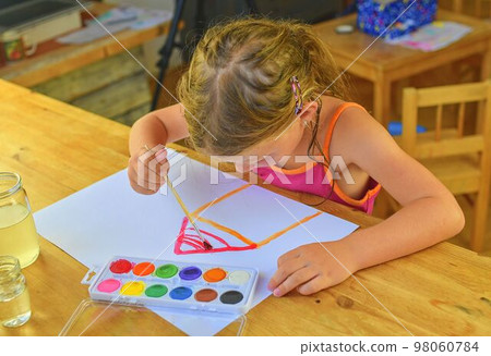 Little girl painting simple picture. Cute girl painting with watercolors Little girl painting simple picture. Cute girl painting with watercolors 98060784