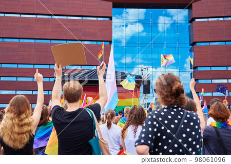 People crowd with LGBTQ rainbow flags on pride parade. Tolerance, diversity and gender identity concept People crowd with LGBTQ rainbow flags on pride parade. Tolerance, diversity and gender identity concept 98061096