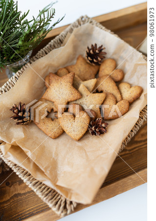 Preparation of gingerbread, different gingerbreads of different shapes lie on a wooden tray, top view. Holiday concept. Preparation of gingerbread, different gingerbreads of different shapes lie on a wooden tray, top view. Holiday concept. 98061973
