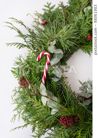 Stylish Christmas wreath for the interior, hang the wreath on the door. Handmade wreath with red festive candy. Festive atmosphere. 98061983