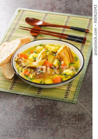 Vietnamese Chicken Curry Ca Ri Ga with tender chicken, rich curry with potatoes and carrots close-up in a plate. Vertical 98062043