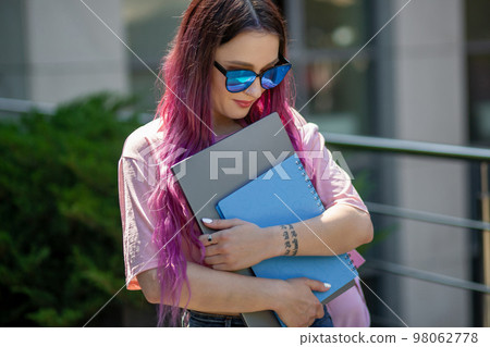 Portrait beautiful female writer dressed in casual outfit holding modern laptop in hand. Portrait beautiful female writer dressed in casual outfit holding modern laptop in hand. 98062778