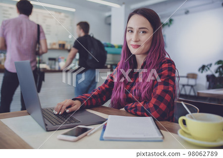 Young woman with pink hair with laptop computer sitting in cafe, Young woman with pink hair with laptop computer sitting in cafe, 98062789