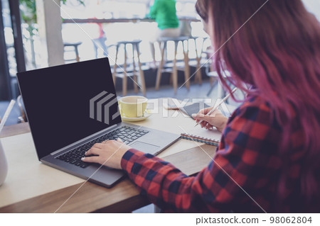 Woman typing on notebook with blank screen with copy space for y 98062804