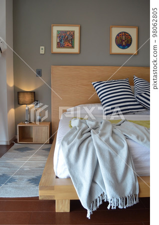 bed base, bedroom with mat on the floor, clay pot in the background, wooden credenza and mirror. bed base, bedroom with mat on the floor, clay pot in the background, wooden credenza and mirror. 98062805