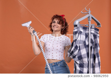 A smile on your face. A steamer for ironing. A girl with curly hair. A smile on your face. A steamer for ironing. A girl with curly hair. 98062950
