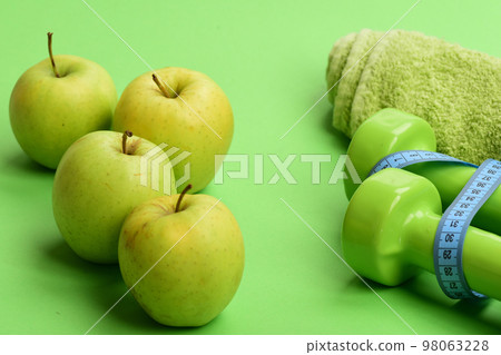 Barbells by juicy green apples. Diet and sport regime concept Barbells by juicy green apples. Diet and sport regime concept 98063228