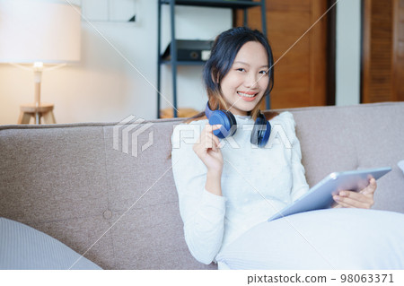 Portrait of a beautiful Asian teenage girl using a tablet computer. 98063371