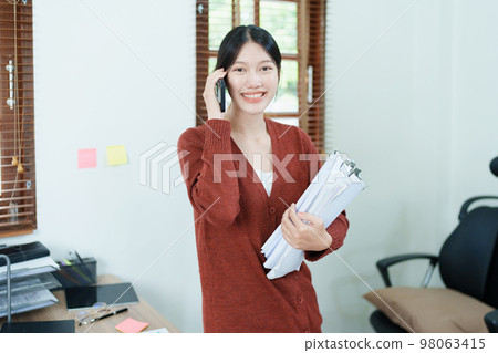 financial, Planning, Marketing and Accounting, portrait of Asian employee checking financial statements using documents and computer at work.. financial, Planning, Marketing and Accounting, portrait of Asian employee checking financial statements using documents and computer at work.. 98063415