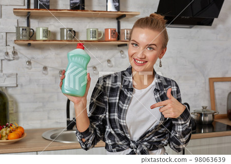 Housekeeper woman holding bottle with cleaner liquid. Bottle copy space 98063639