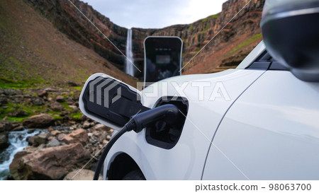 Progressive concept of energy sustainability by EV car in the waterfall. 98063700