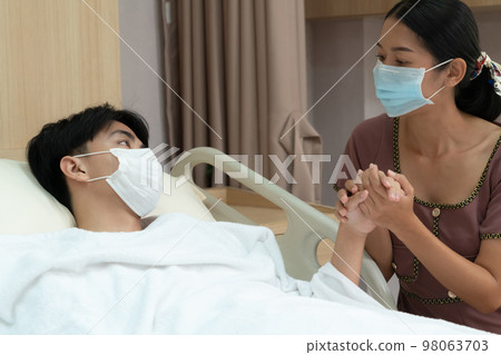Young patient with attentive visitor in hospital's sterile recovery room. Young patient with attentive visitor in hospital's sterile recovery room. 98063703