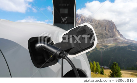 Progressive travel concept by EV car in remote mountain with charging station. Progressive travel concept by EV car in remote mountain with charging station. 98063816
