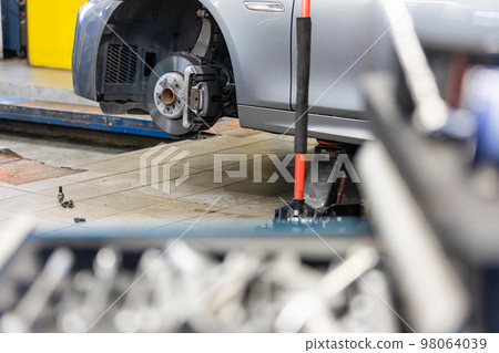 Car service center concept, vehicle raised on lift at maintenance station, auomobile repair, check up, repairing the car Car service center concept, vehicle raised on lift at maintenance station, auomobile repair, check up, repairing the car 98064039