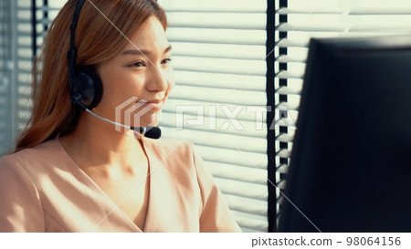 Competent female operator working on computer and while talking with clients. Competent female operator working on computer and while talking with clients. 98064156