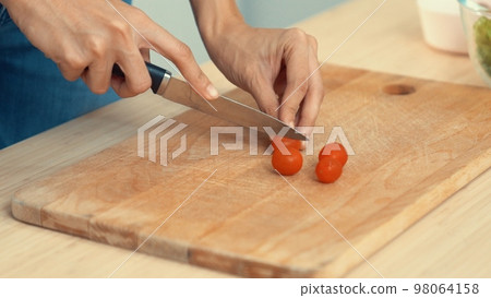 Close up hands holding a knife preparing a contented meal. Close up hands holding a knife preparing a contented meal. 98064158